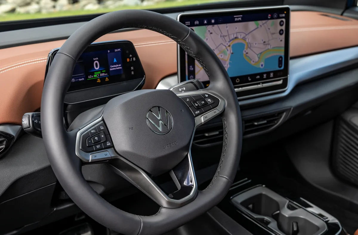 Interior do VW ID.4 com volante, painel digital e central multimídia de 12,9 polegadas exibindo mapa