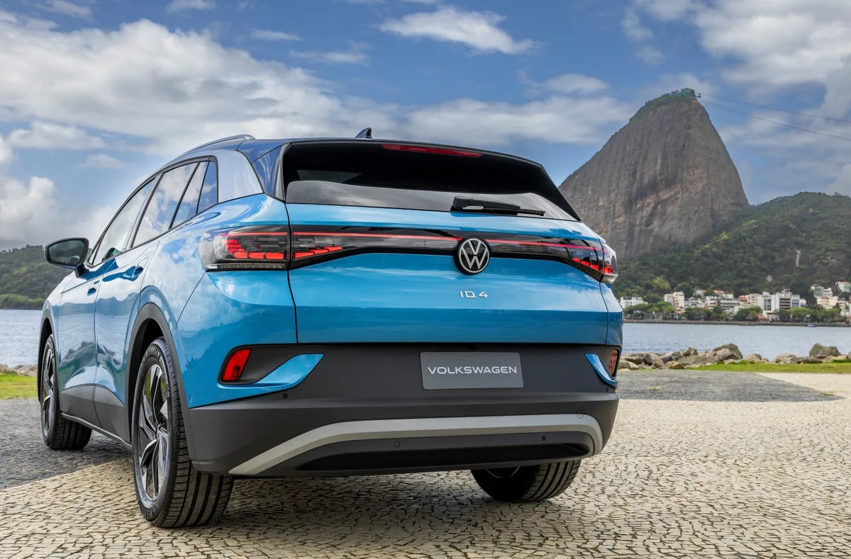 Traseira do VW ID.4 azul com lanternas em LED conectadas por faixa luminosa, com o Pão de Açúcar ao fundo